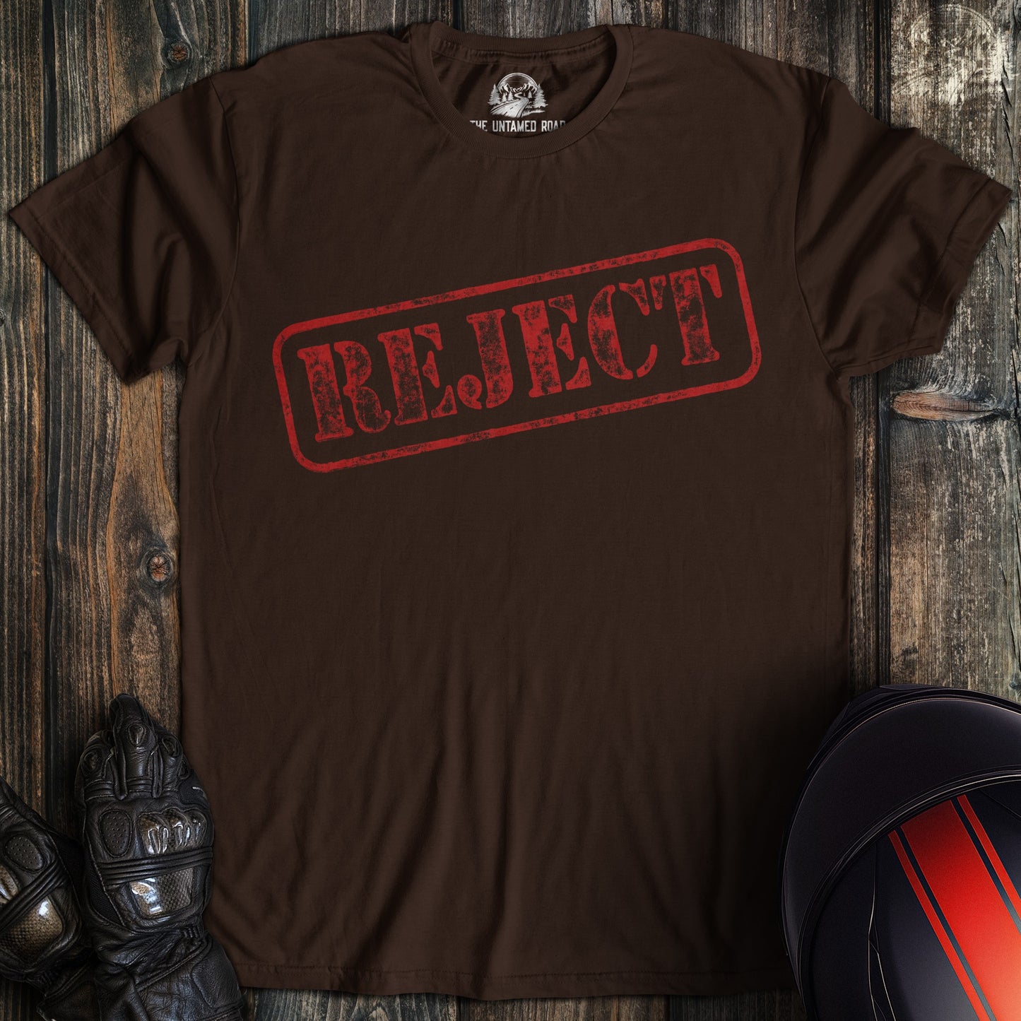 A dark chocolate colored t-shirt with the words "reject" printed on the front.
