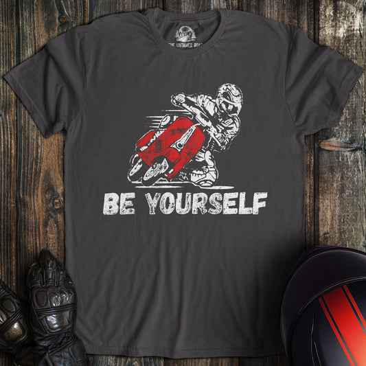 A charcoal colored t-shirt with the words "be yourself" printed on the front.