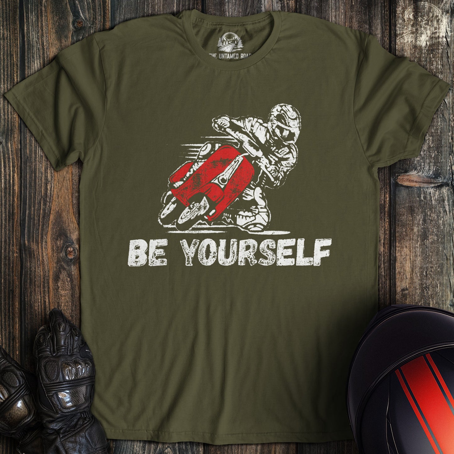 A military green colored t-shirt with the words "be yourself" printed on the front.