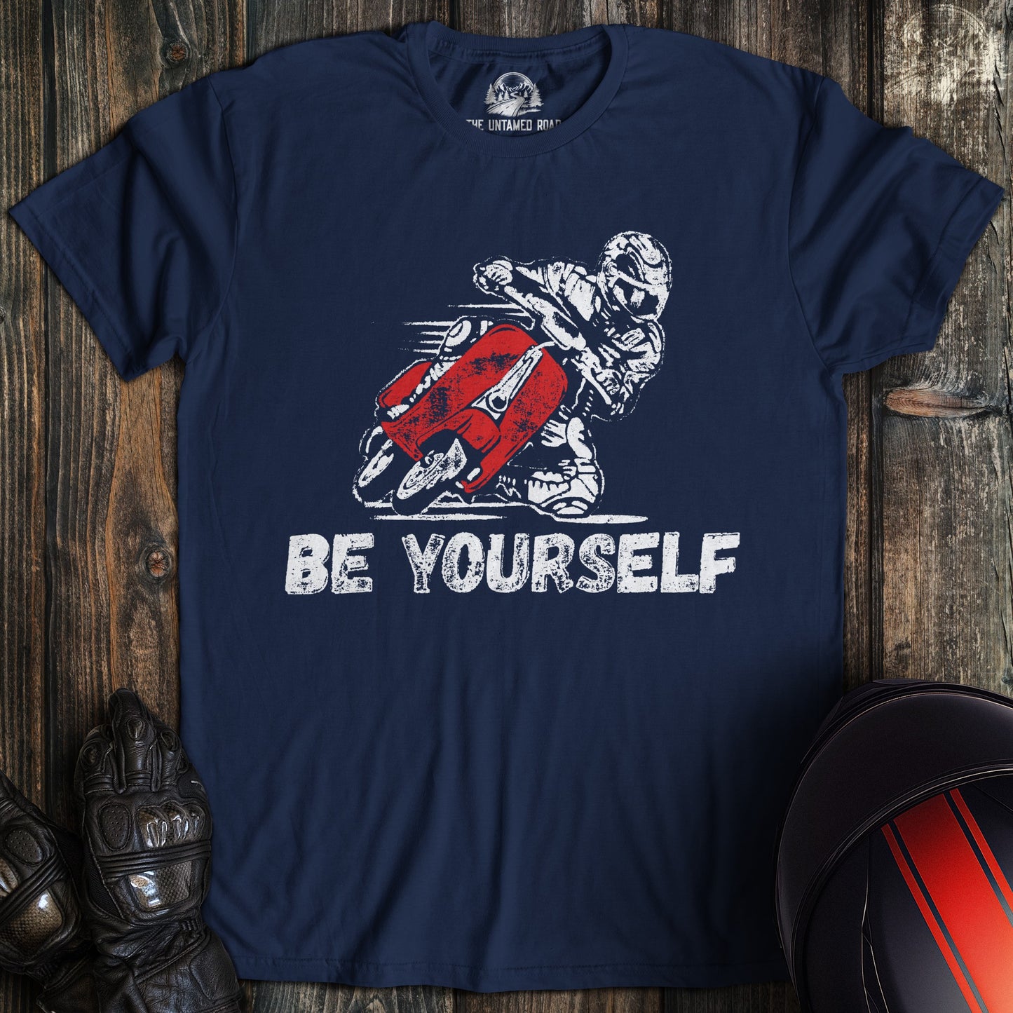 A navy colored t-shirt with the words "be yourself" printed on the front.