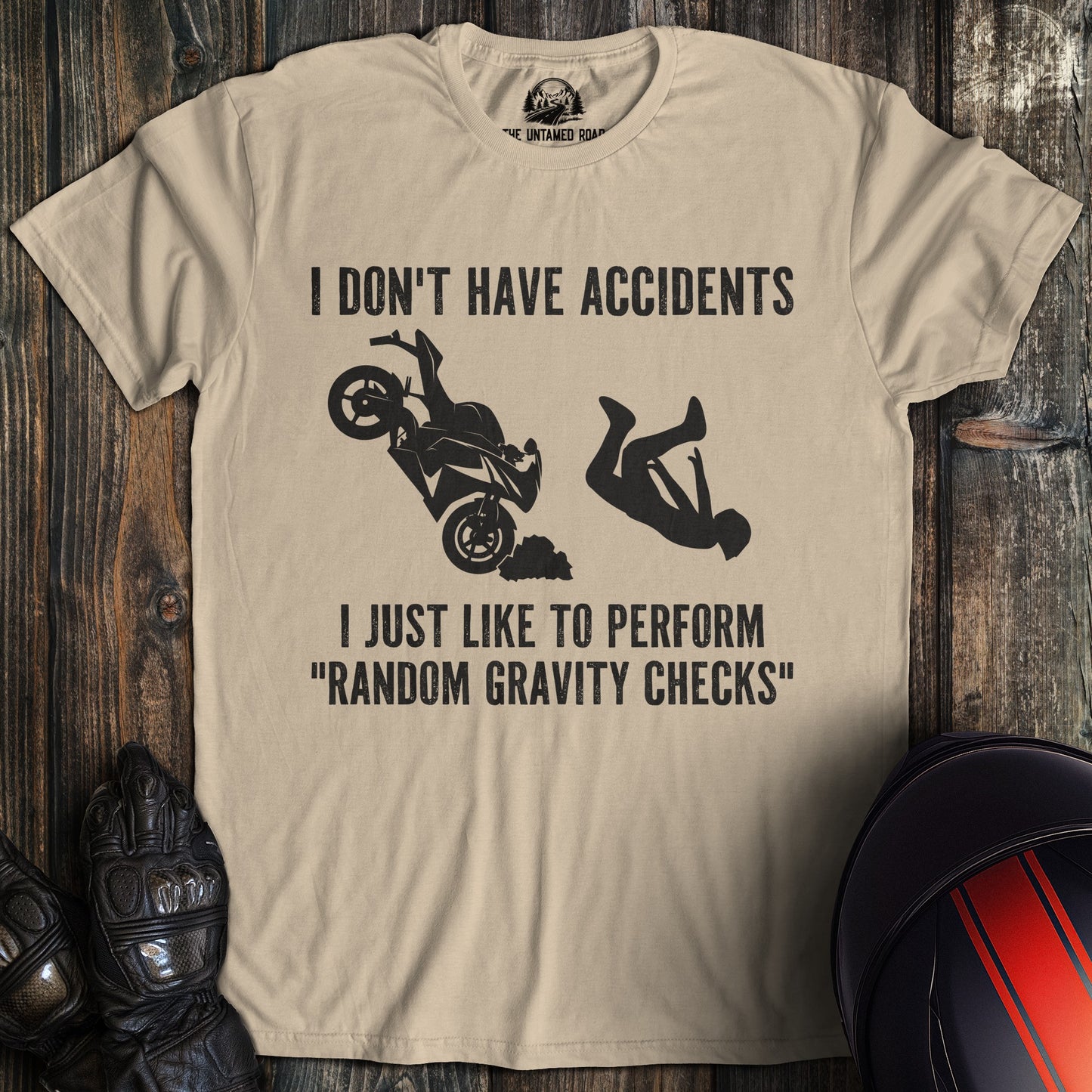 A sand colored t-shirt with the words "random gravity checks" printed on the front.