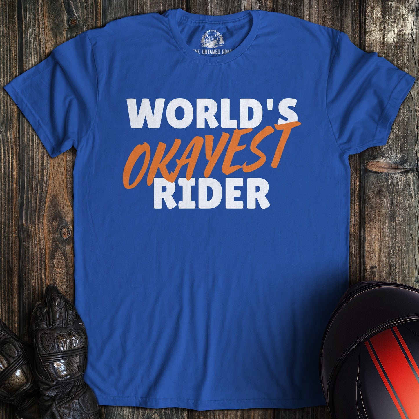 A royal blue colored t-shirt with the words "worlds okayest rider" printed on the front.