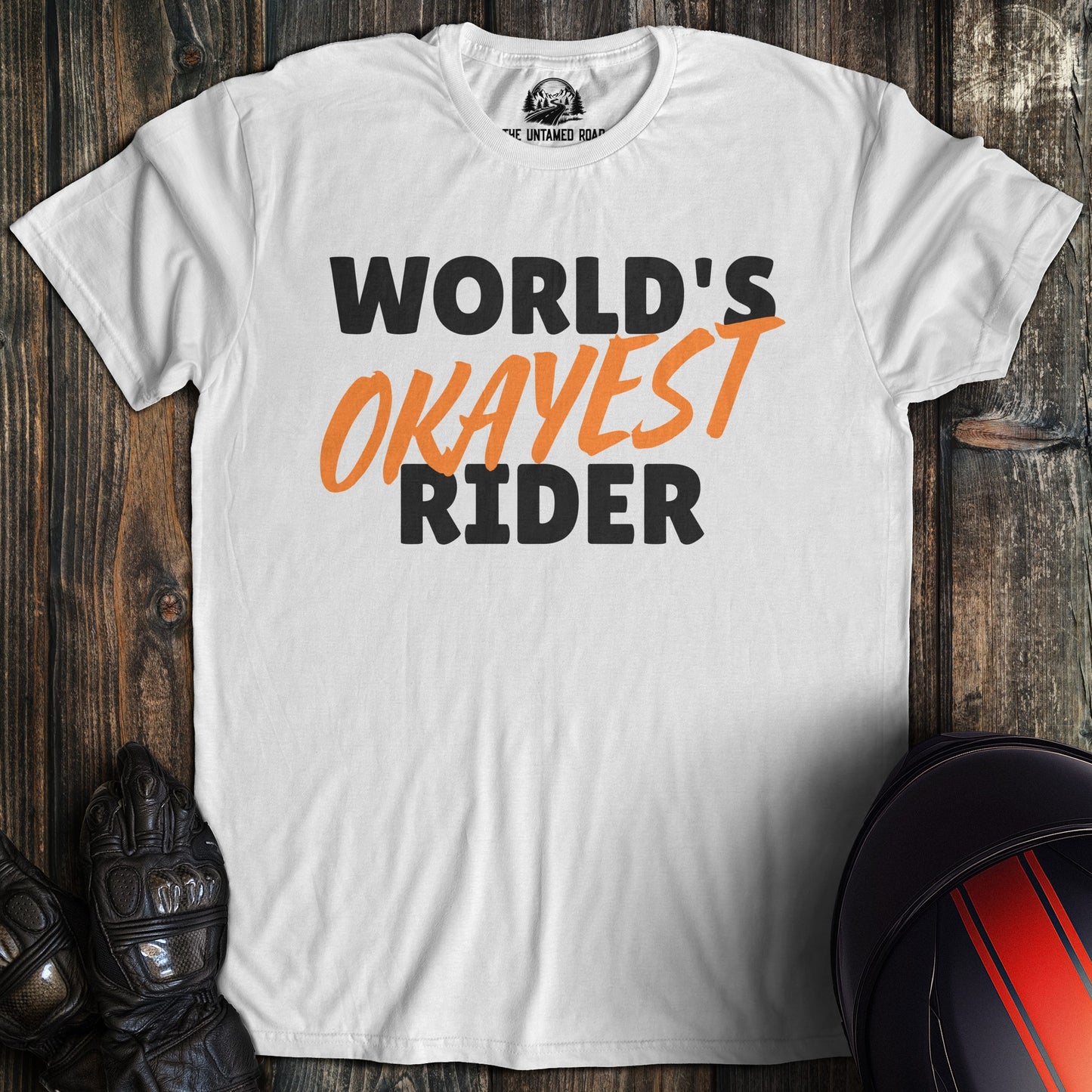 A white colored t-shirt with the words "worlds okayest rider" printed on the front.