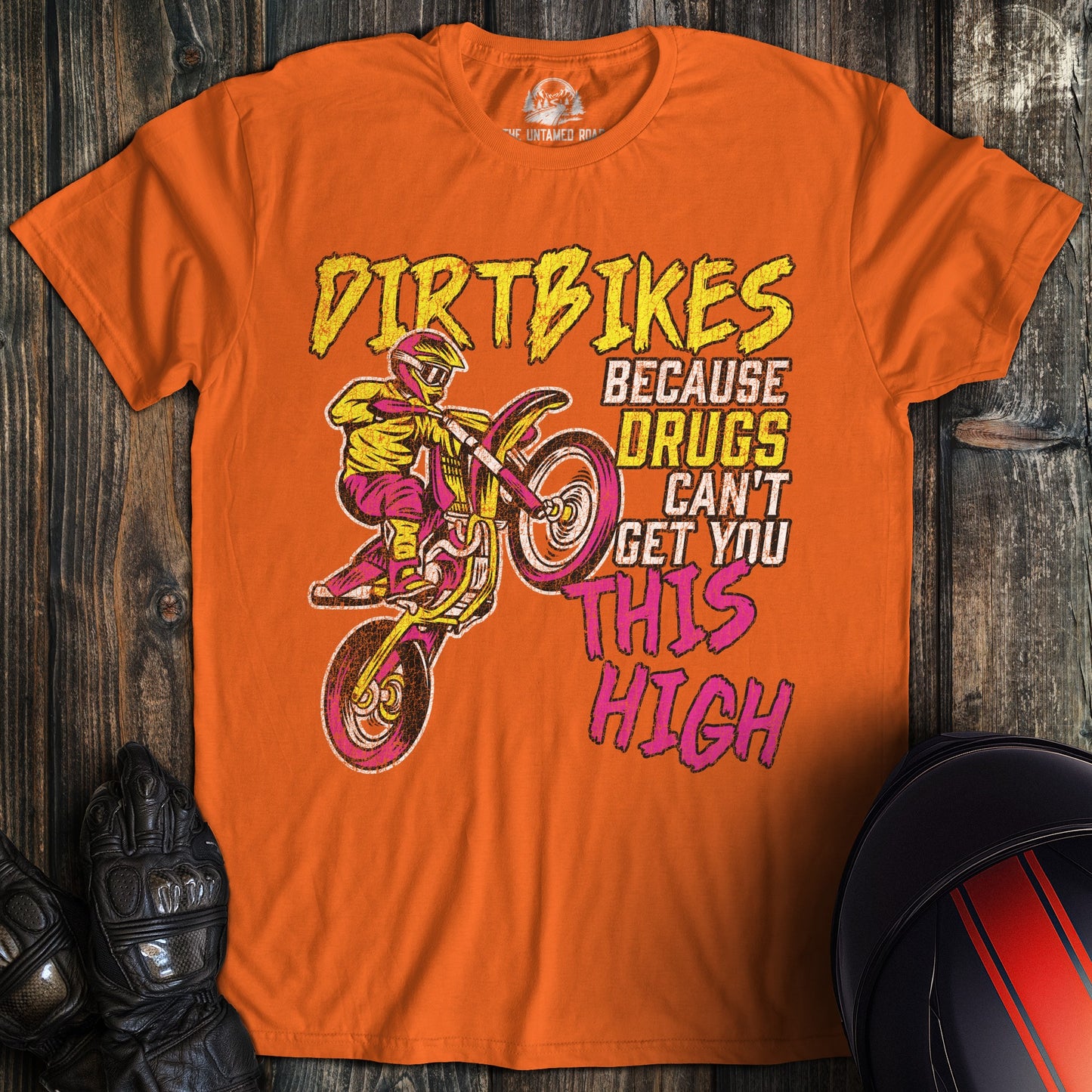 A orange colored t-shirt with the words "motocross drugs" printed on the front.