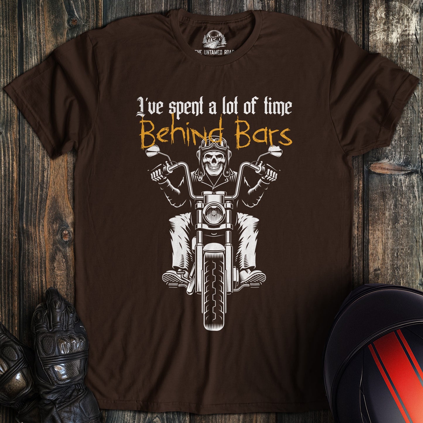 A dark chocolate colored t-shirt with the words "time behind bars" printed on the front.