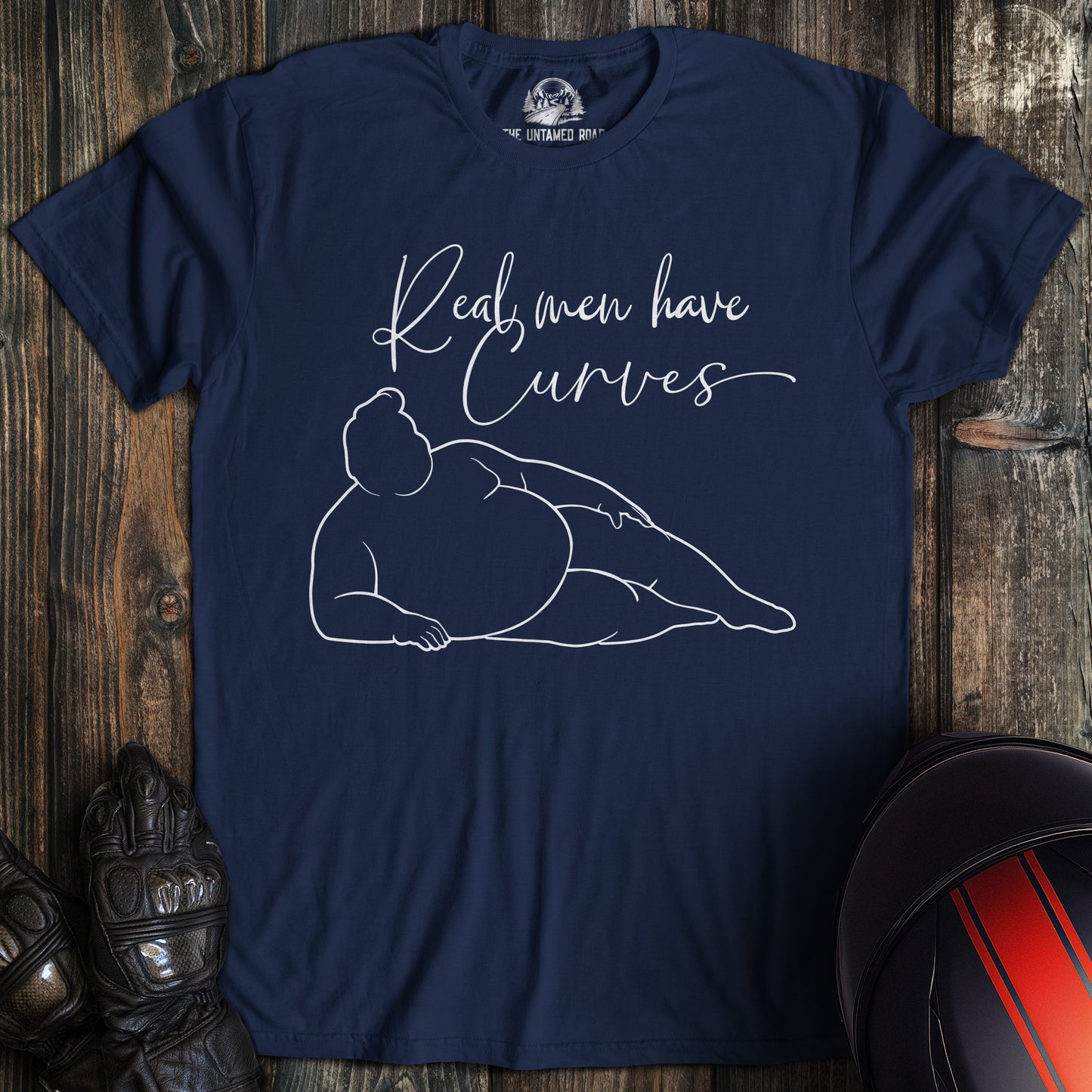 A navy colored t-shirt with the words "real men have curves" printed on the front.