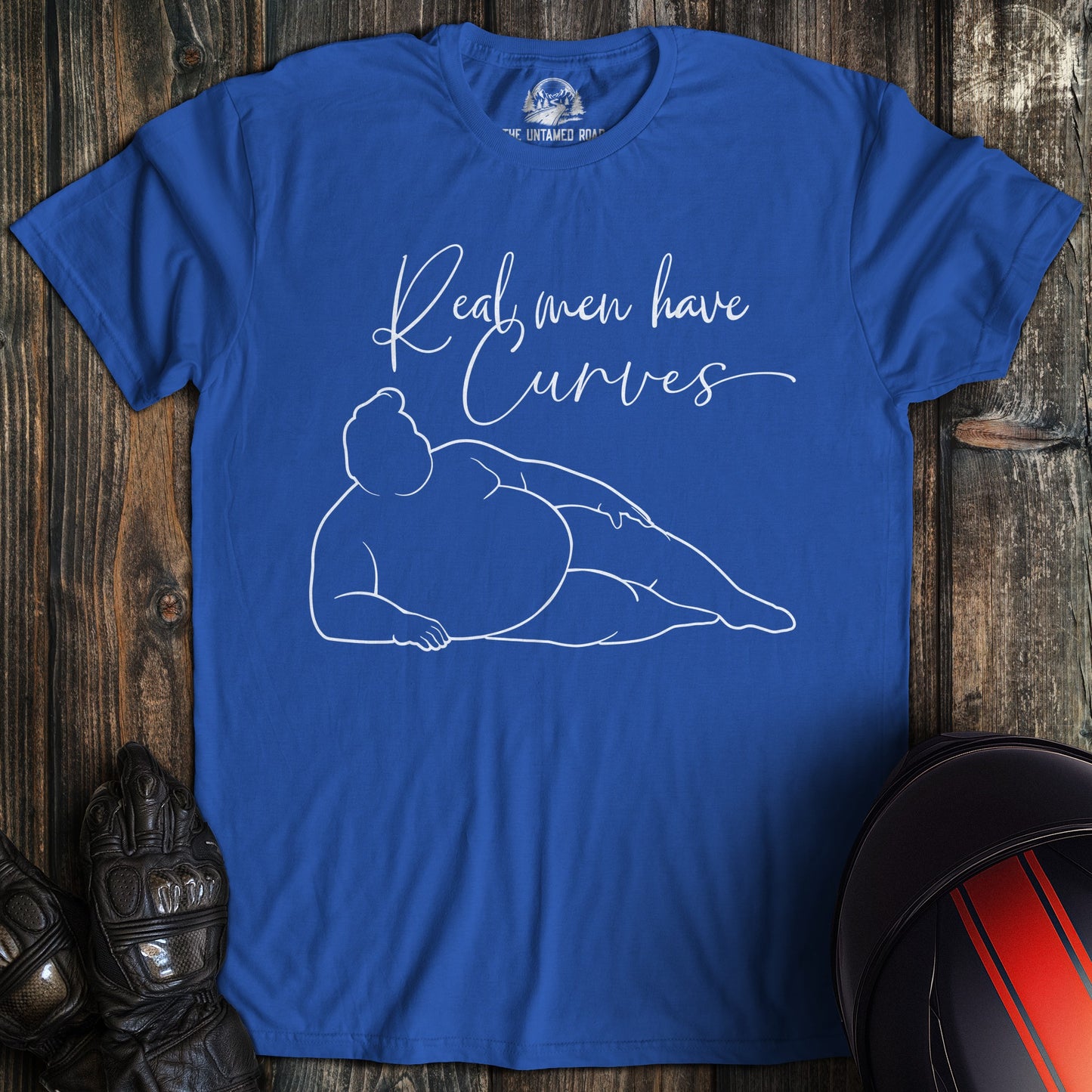 A royal blue colored t-shirt with the words "real men have curves" printed on the front.