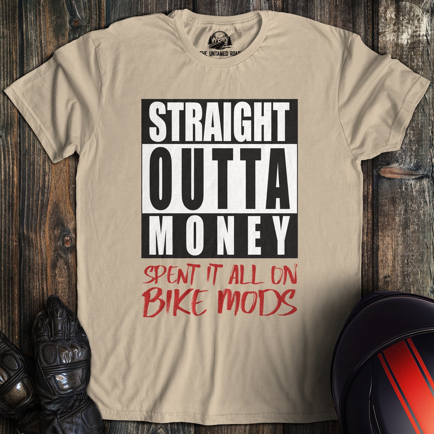 A sand colored t-shirt with the words "straight outta money" printed on the front.