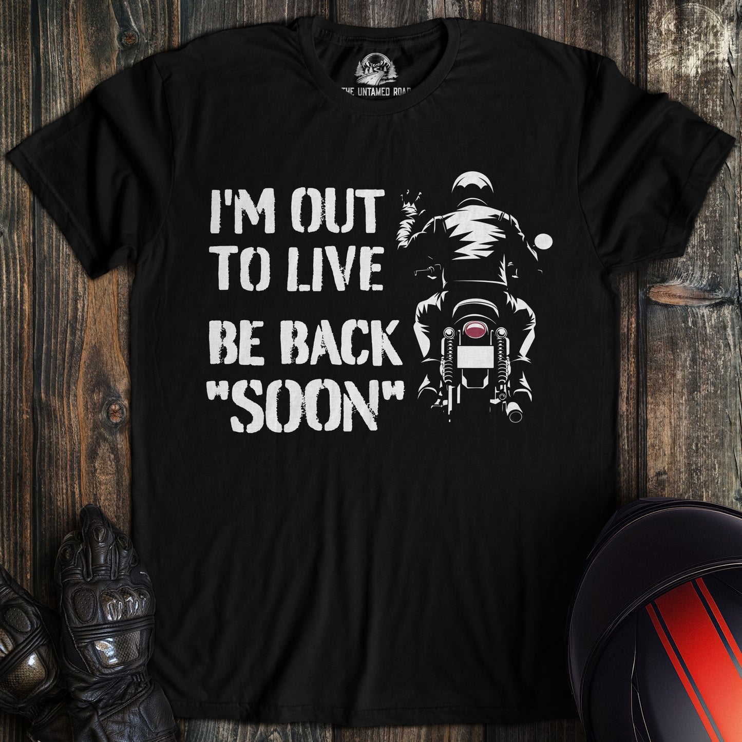 A black colored t-shirt with the words "out to live be back soon" printed on the front.