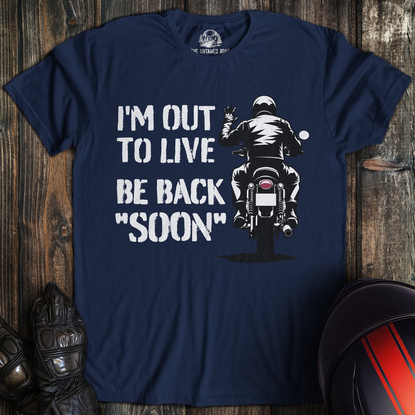 A navy colored t-shirt with the words "out to live be back soon" printed on the front.