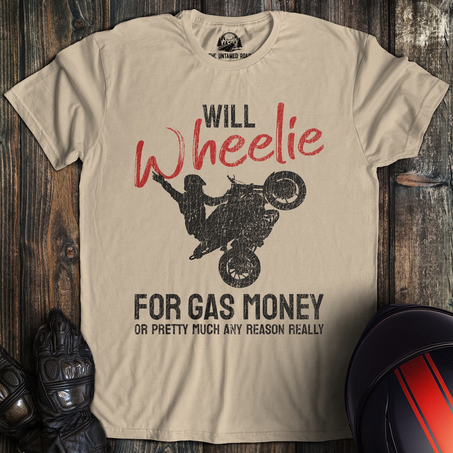 A sand colored t-shirt with the words "wheelie for money" printed on the front.