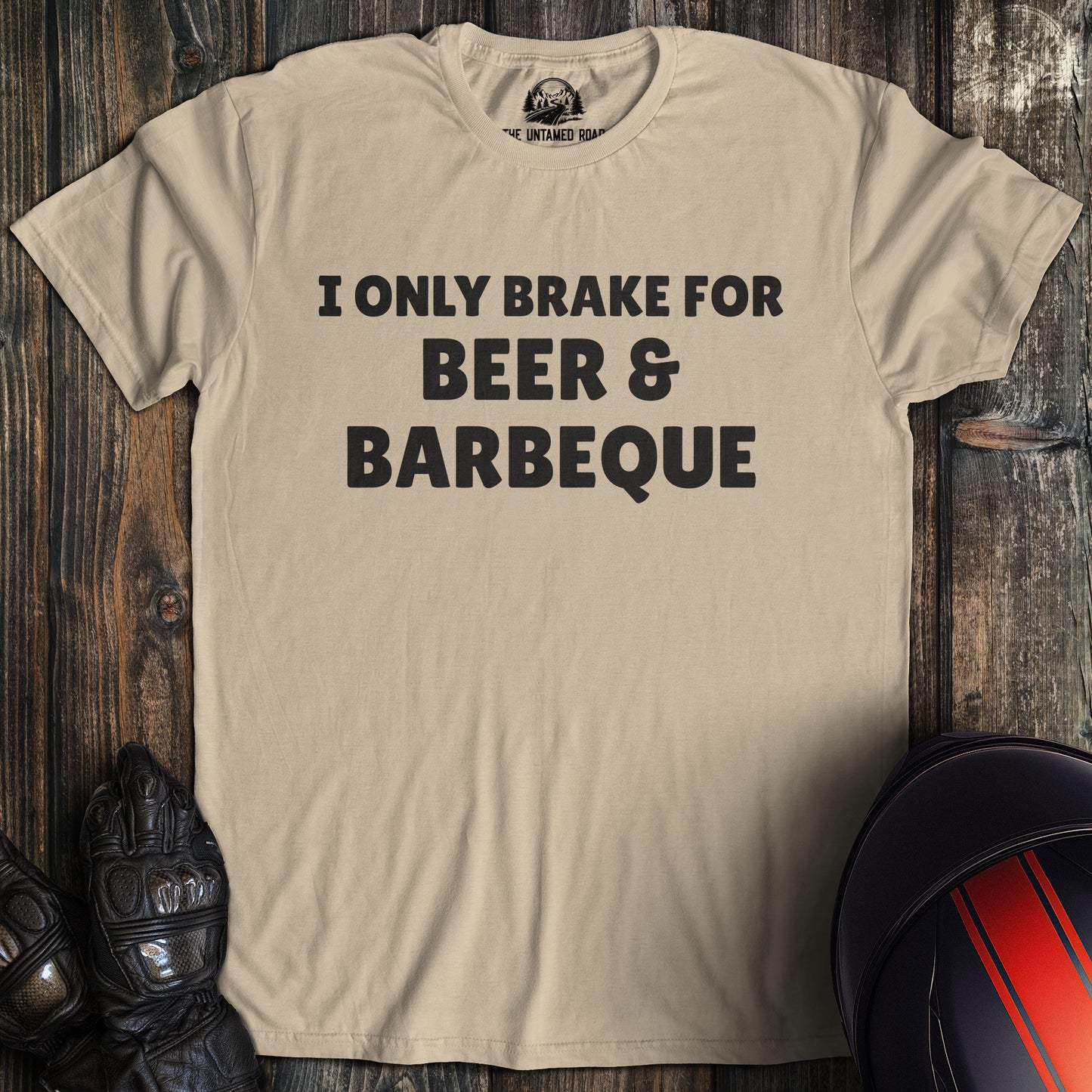 A sand colored t-shirt with the words "brake for beer and bbq" printed on the front.