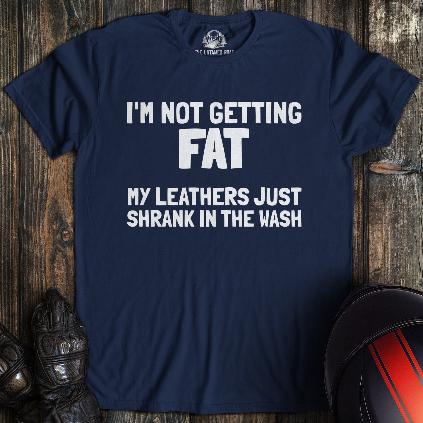 A navy colored t-shirt with the words "not fat leathers shrank" printed on the front.