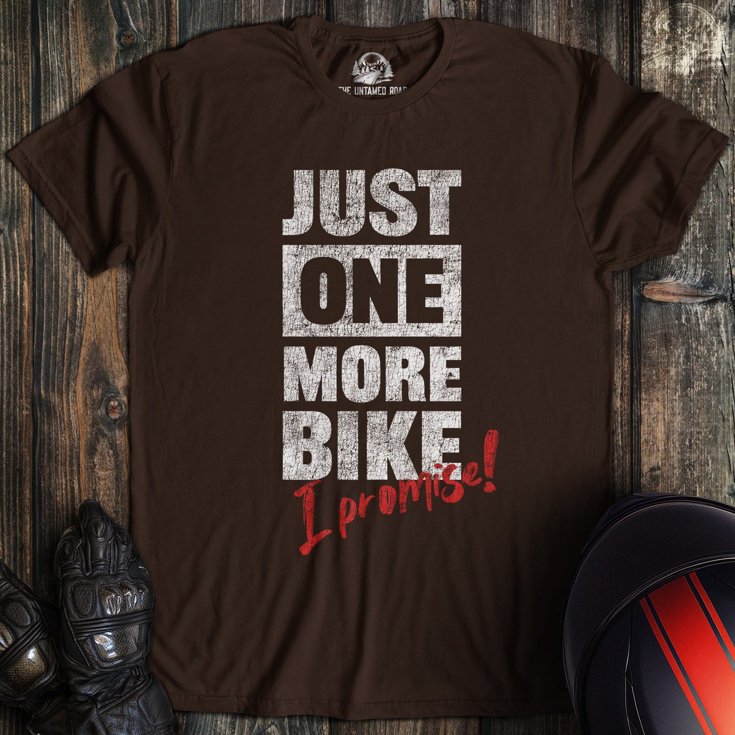 A dark chocolate colored t-shirt with the words "just one more bike" printed on the front.
