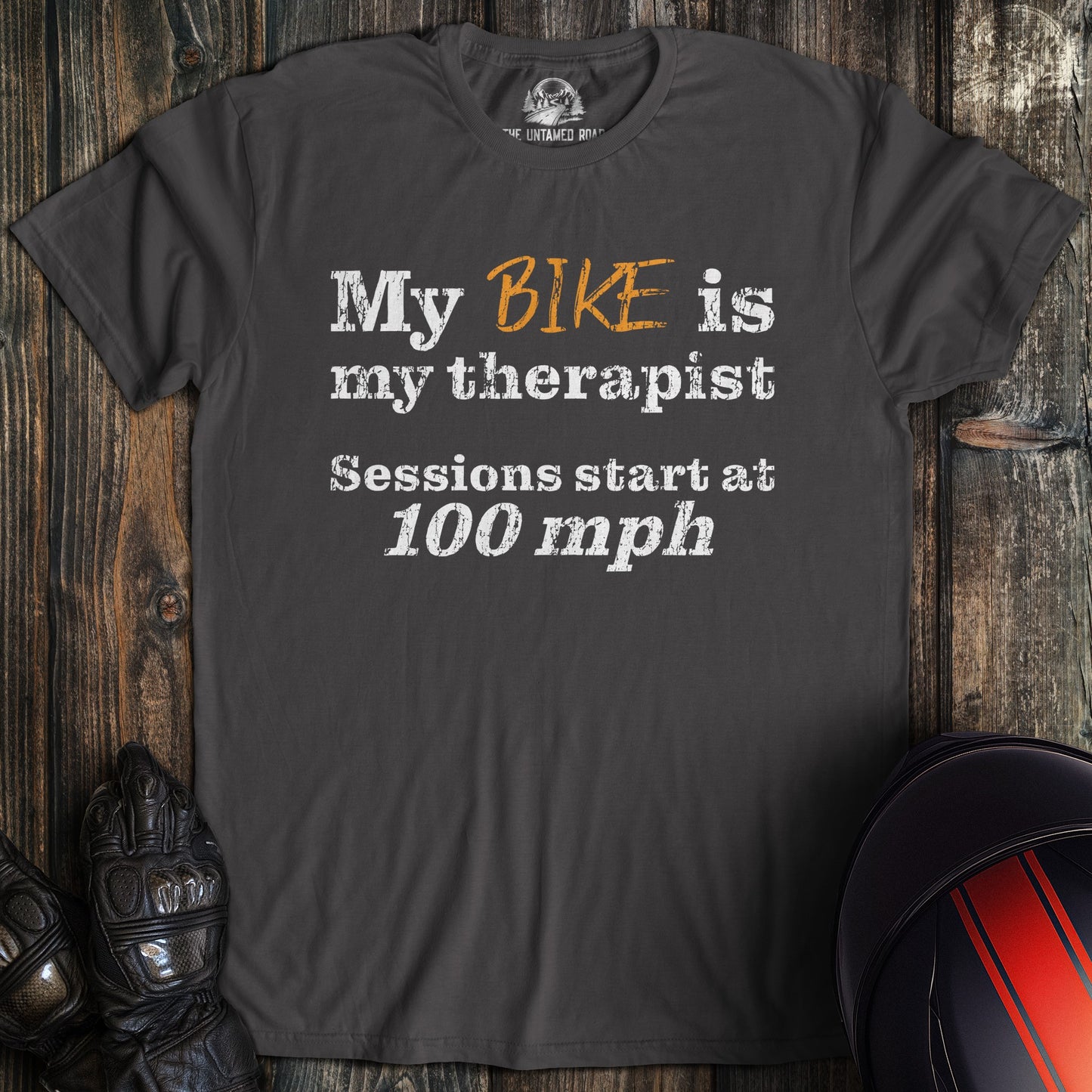 A charcoal colored t-shirt with the words "bike is therapist" printed on the front.