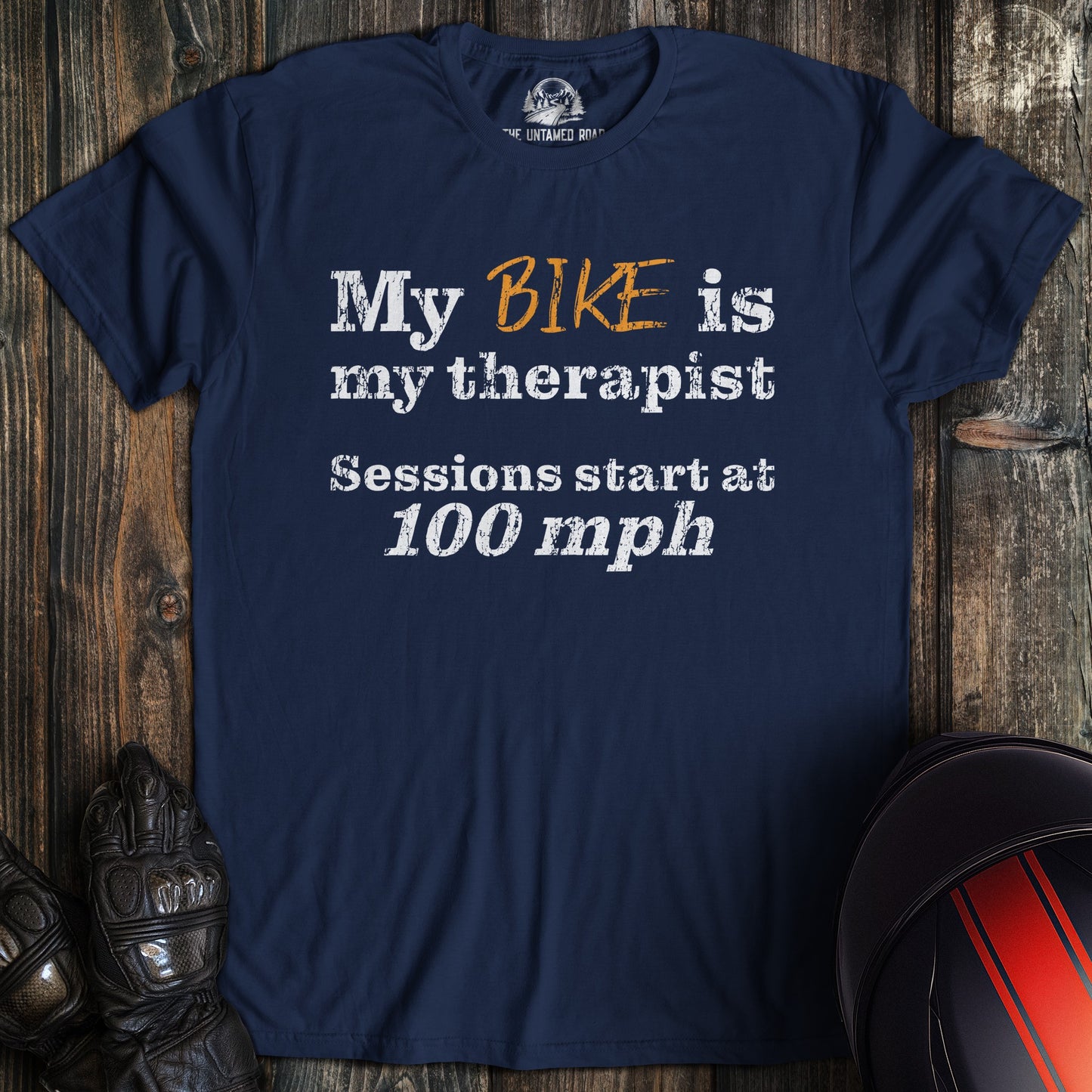 A navy colored t-shirt with the words "bike is therapist" printed on the front.