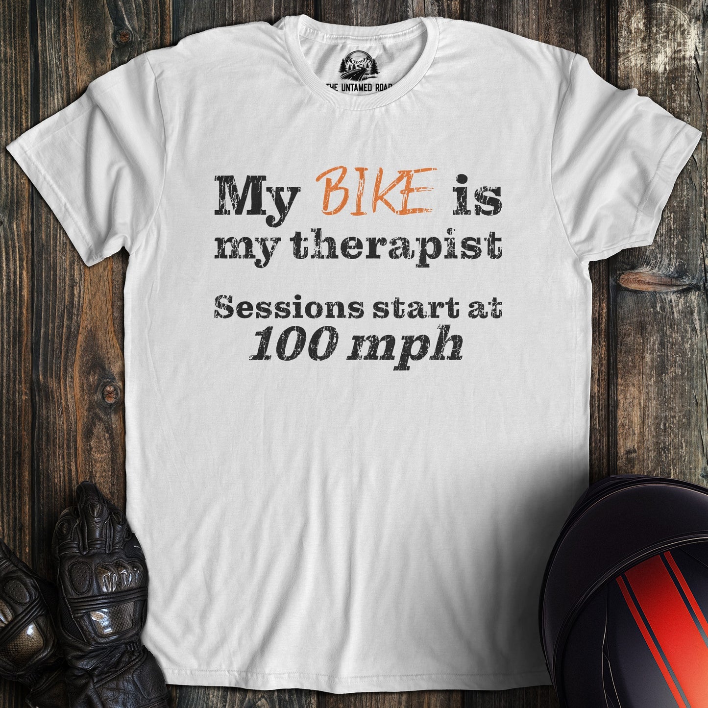 A white colored t-shirt with the words "bike is therapist" printed on the front.