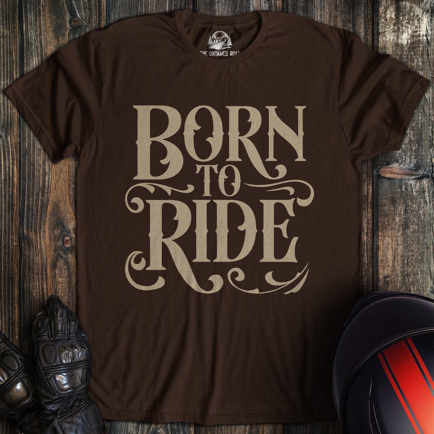 A dark chocolate colored t-shirt with the words "born to ride gothic" printed on the front.