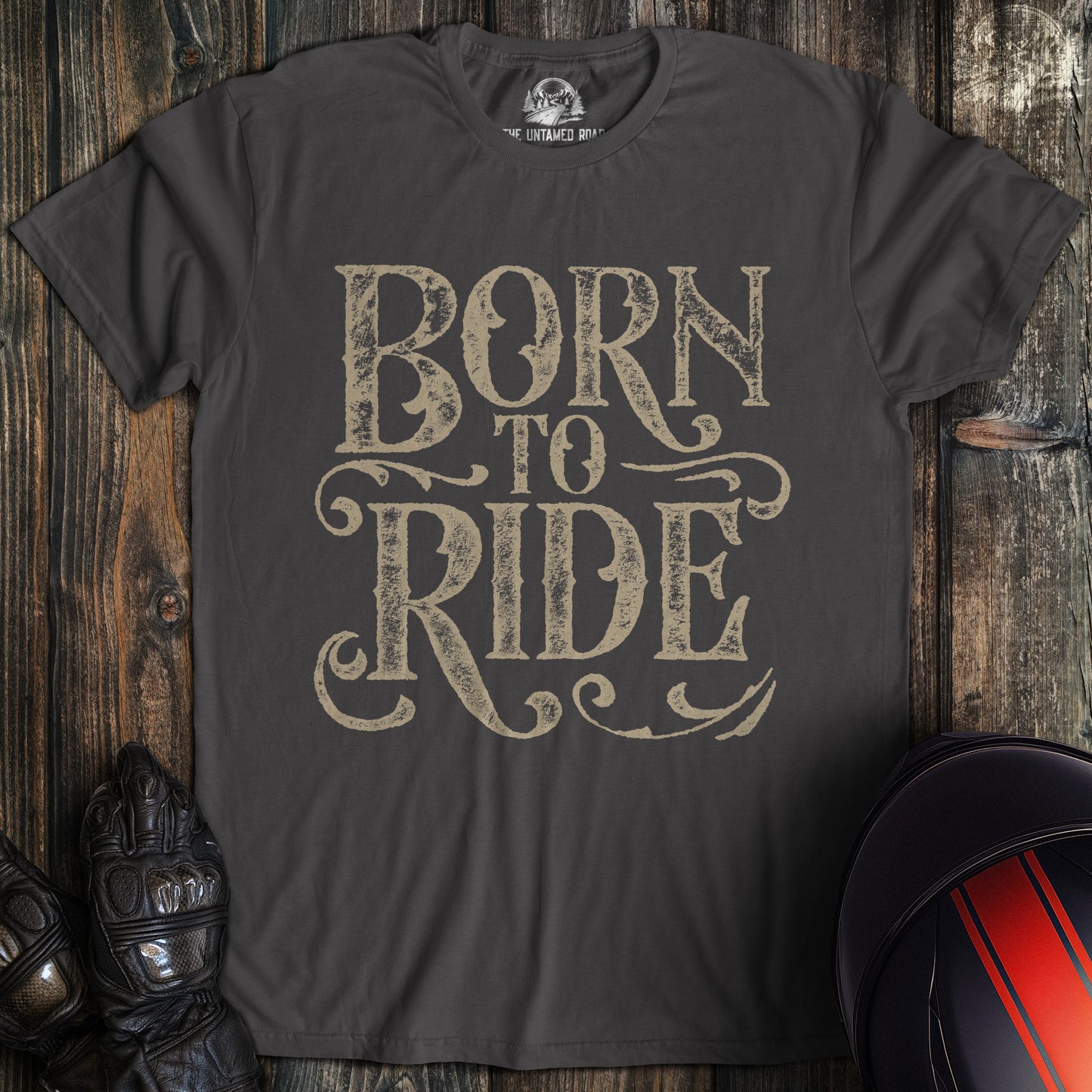 A charcoal colored t-shirt with the words "born to ride gothic grunge" printed on the front.