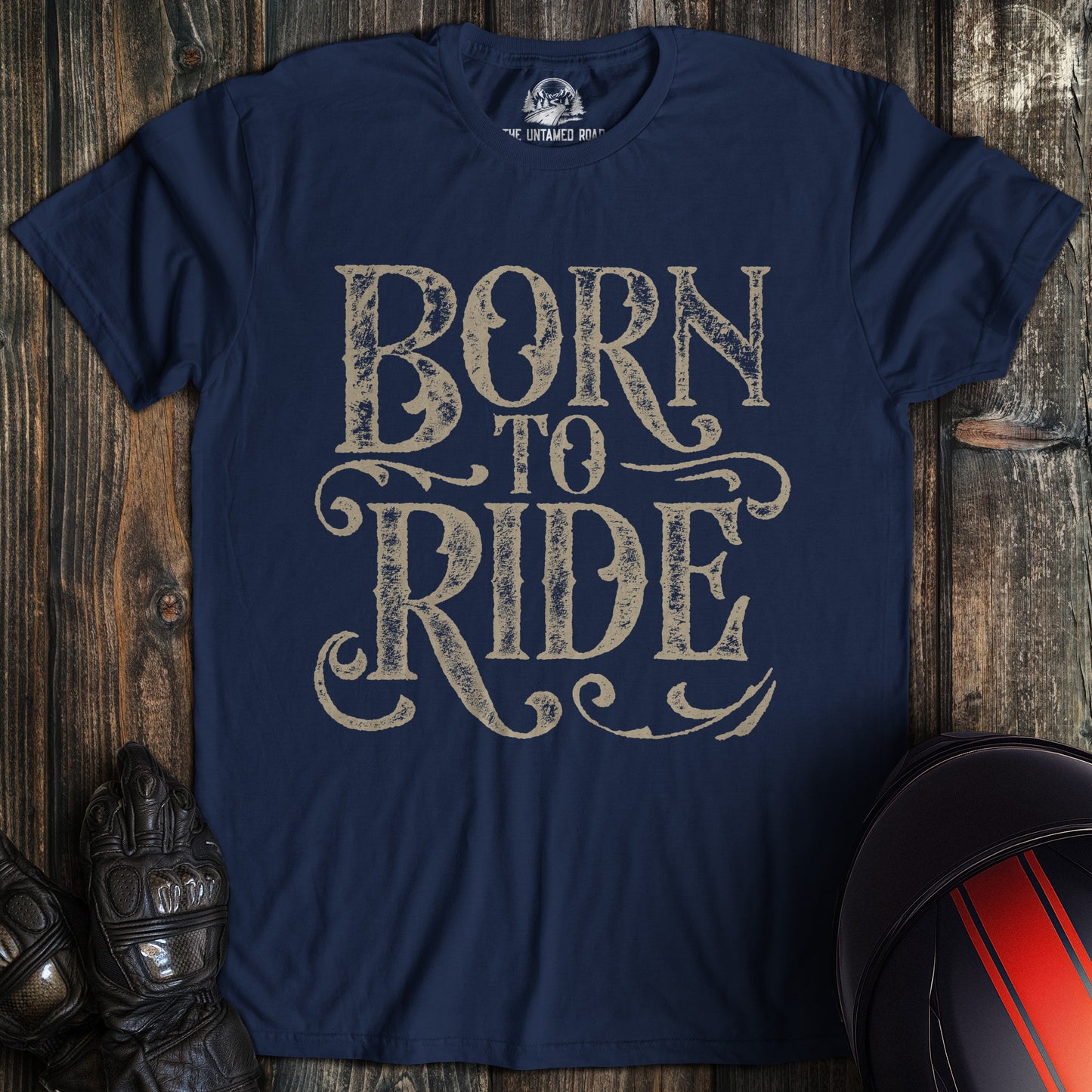 A navy colored t-shirt with the words "born to ride gothic grunge" printed on the front.