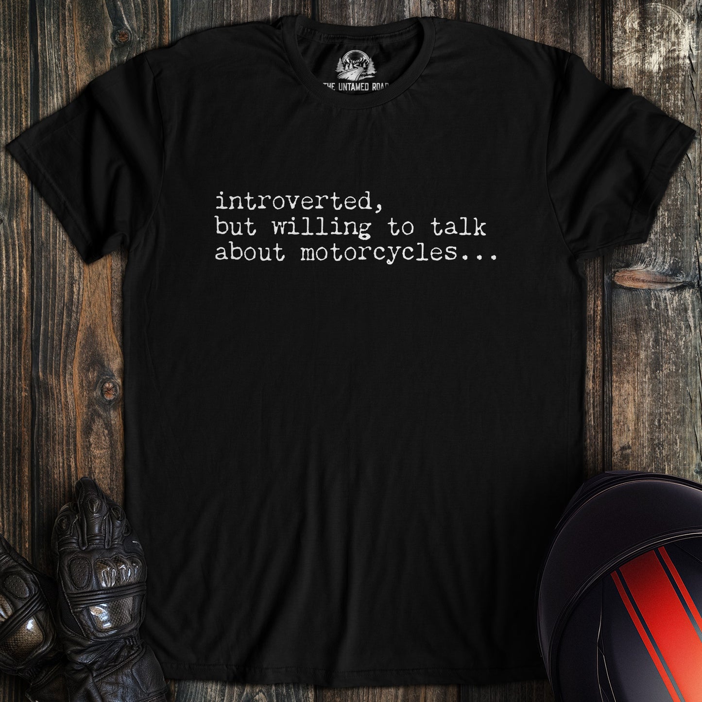 A black colored t-shirt with the words "introverted but willing to talk" printed on the front.