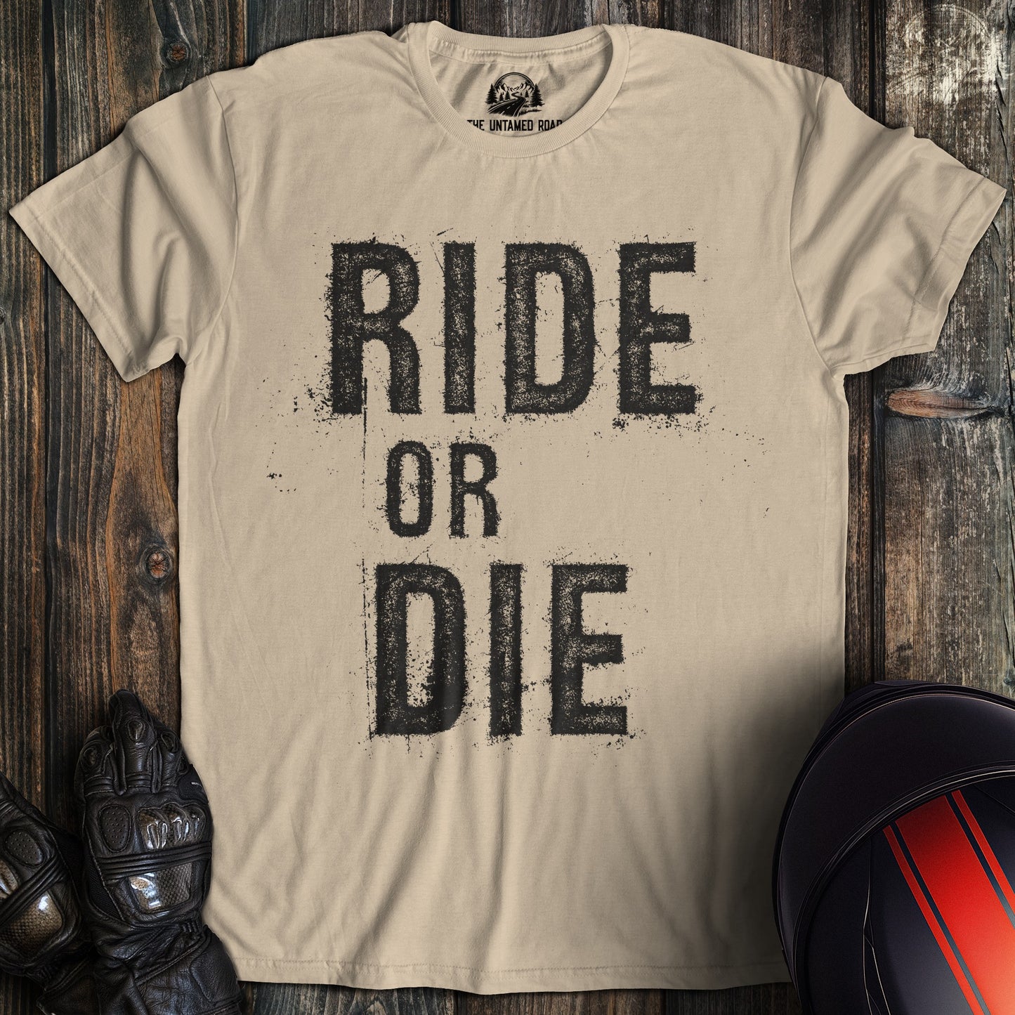 A sand colored t-shirt with the words "ride or die" printed on the front.
