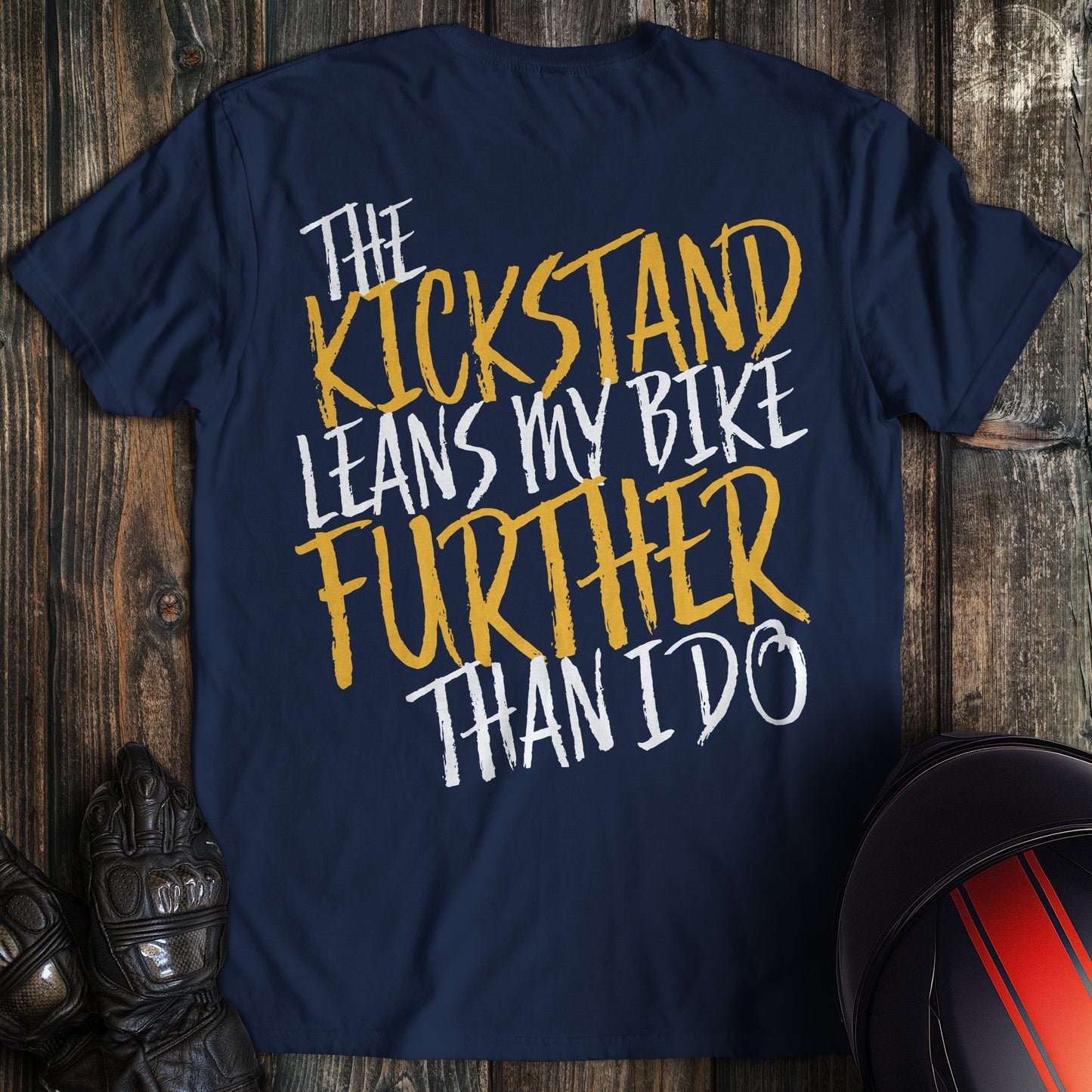 A navy colored t-shirt with the words "kickstand leans further" printed on the back.
