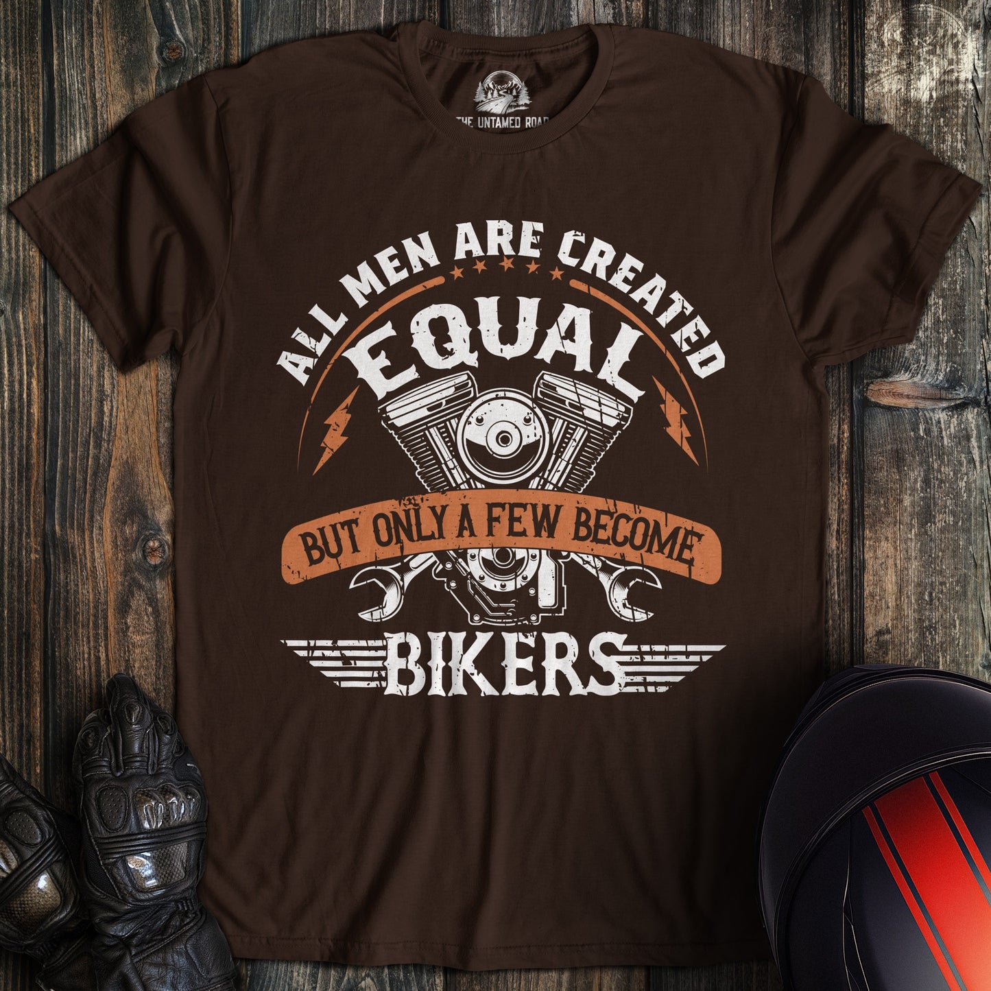 A dark chocolate colored t-shirt with the words "men created equal" printed on the front.