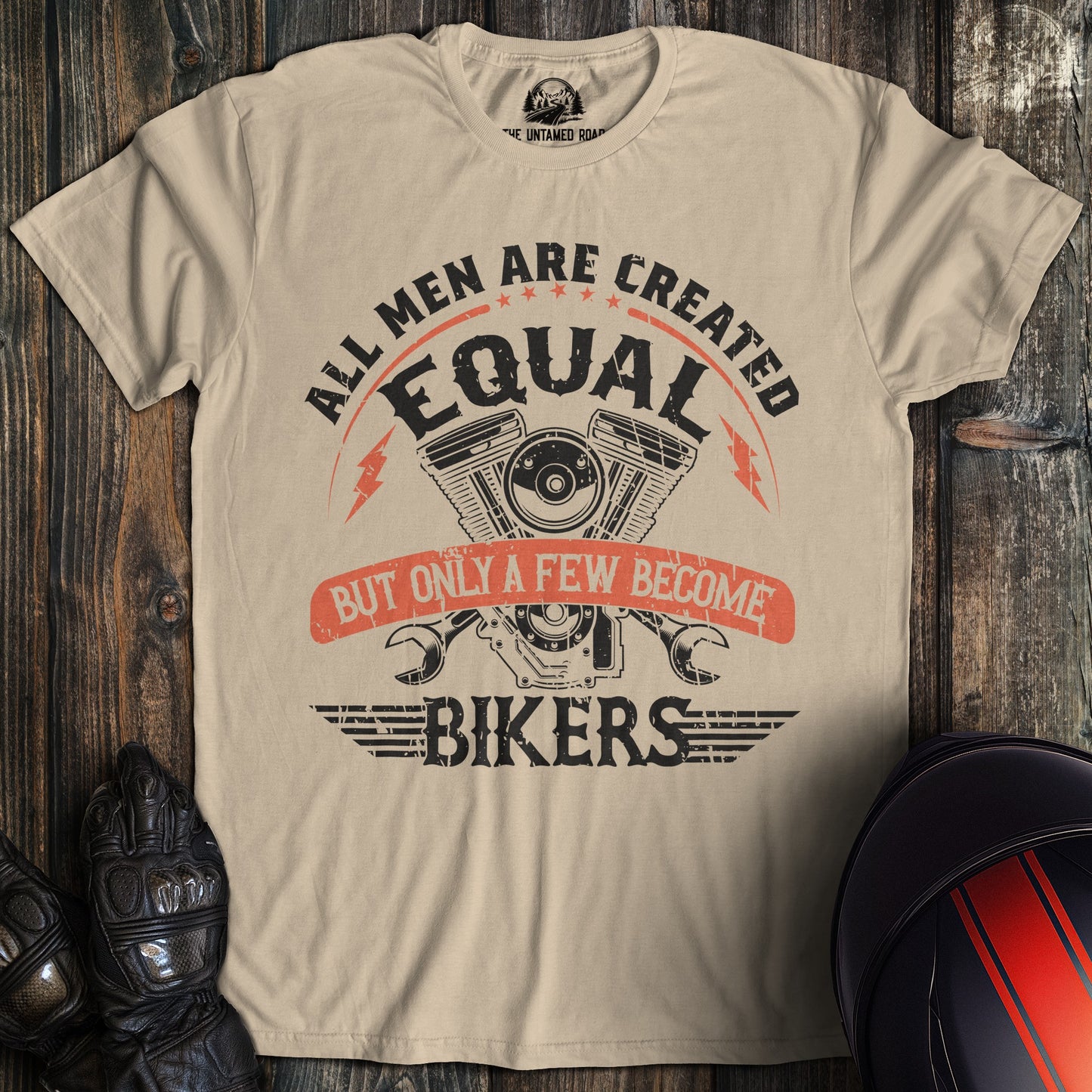A sand colored t-shirt with the words "men created equal" printed on the front.
