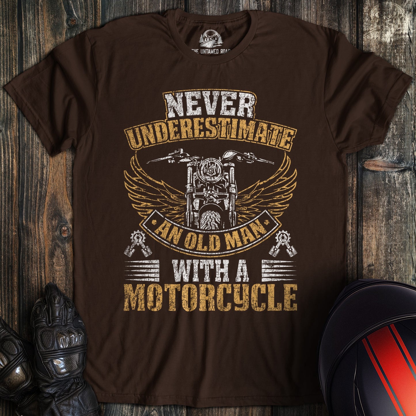 A dark chocolate colored t-shirt with the words "old man motorcycle distressed" printed on the front.