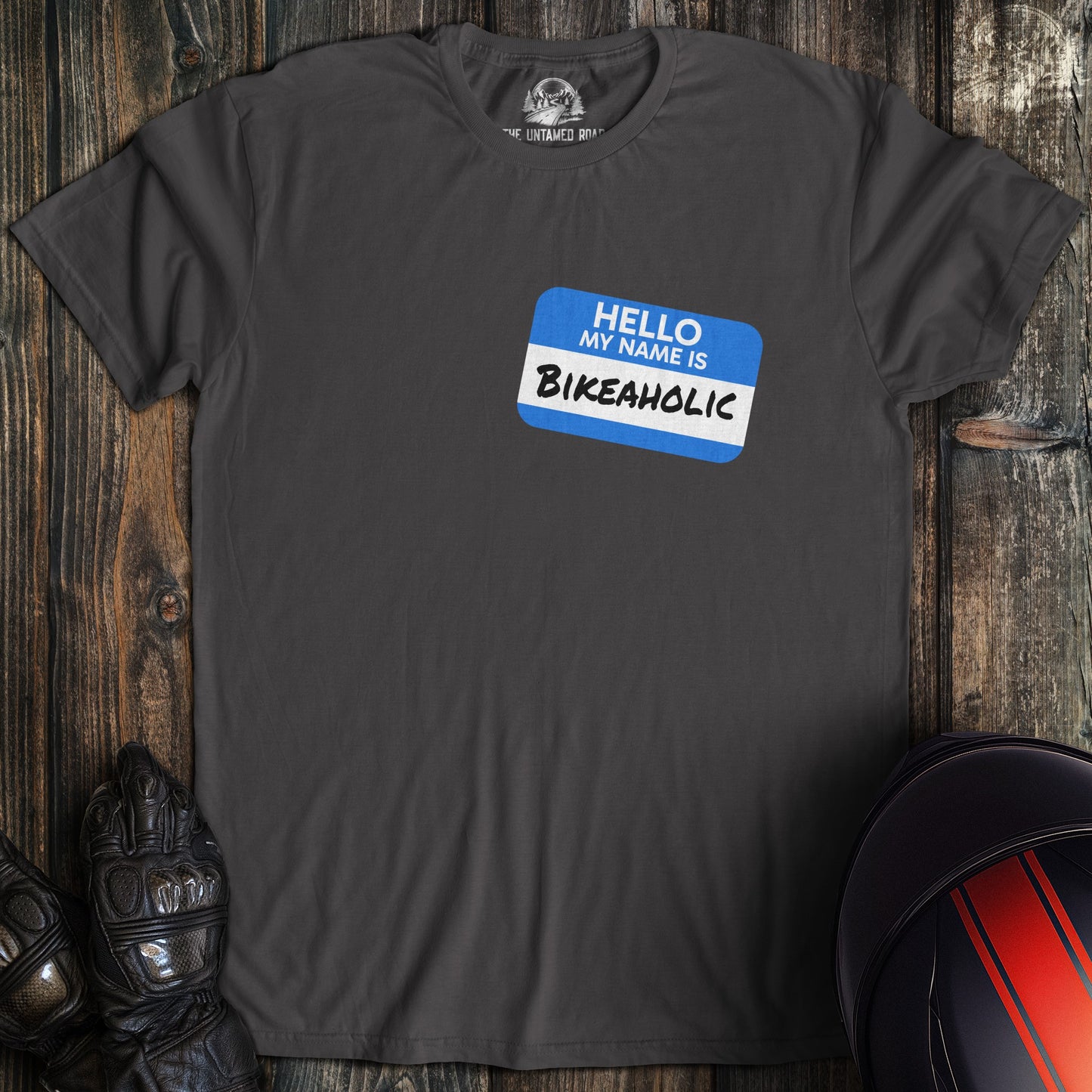 A charcoal colored t-shirt with the words "bikeaholic nametag" printed on the front.