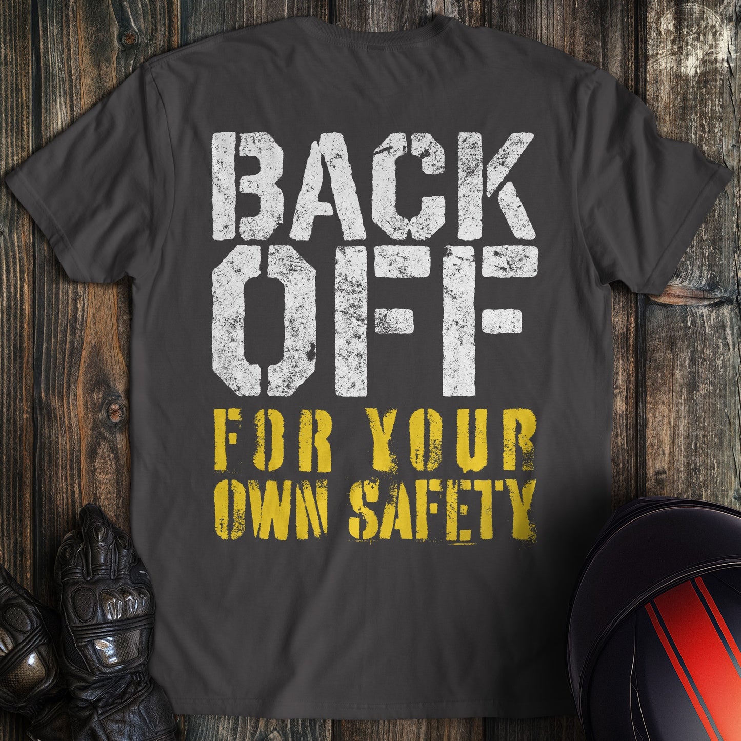 A charcoal colored t-shirt with the words "back off for your safety" printed on the back.