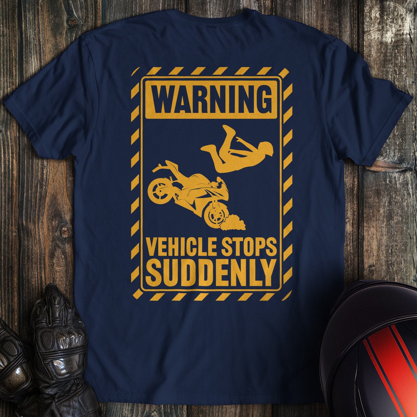 A navy colored t-shirt with the words "warning vehicle stops suddenly" printed on the back.