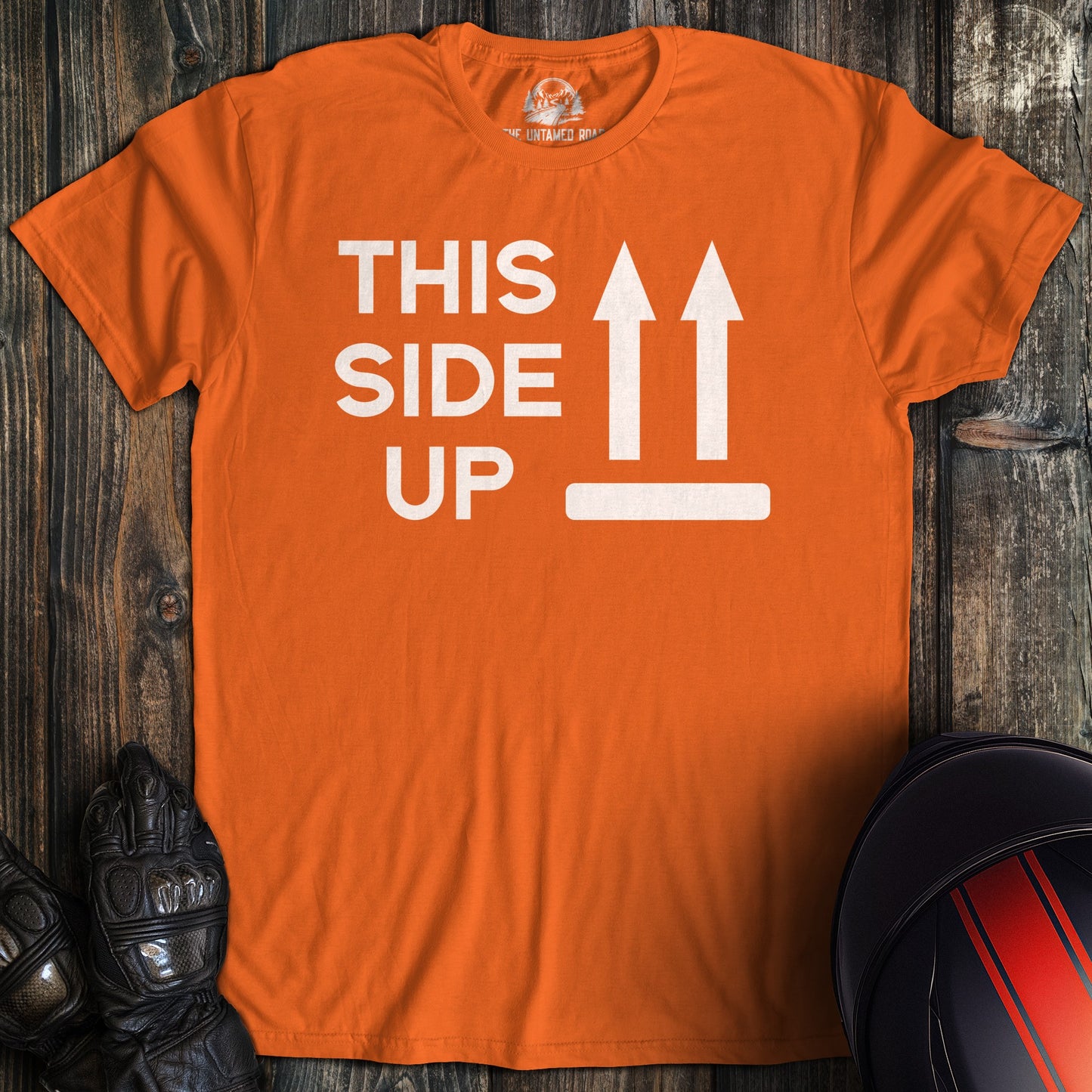 A orange colored t-shirt with the words "this side up" printed on the front.