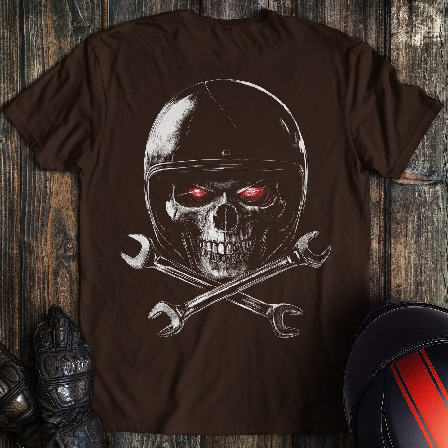 A dark chocolate colored t-shirt with the words "skull and wrenches 2" printed on the back.
