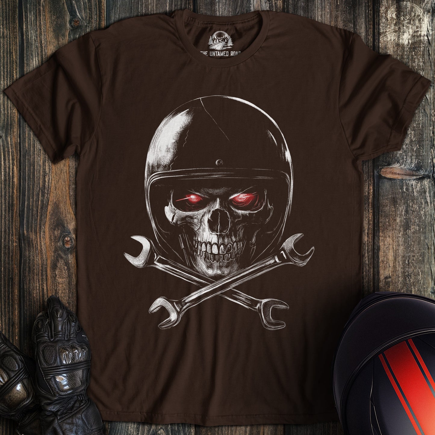 A dark chocolate colored t-shirt with the words "skull and wrenches 2" printed on the front.