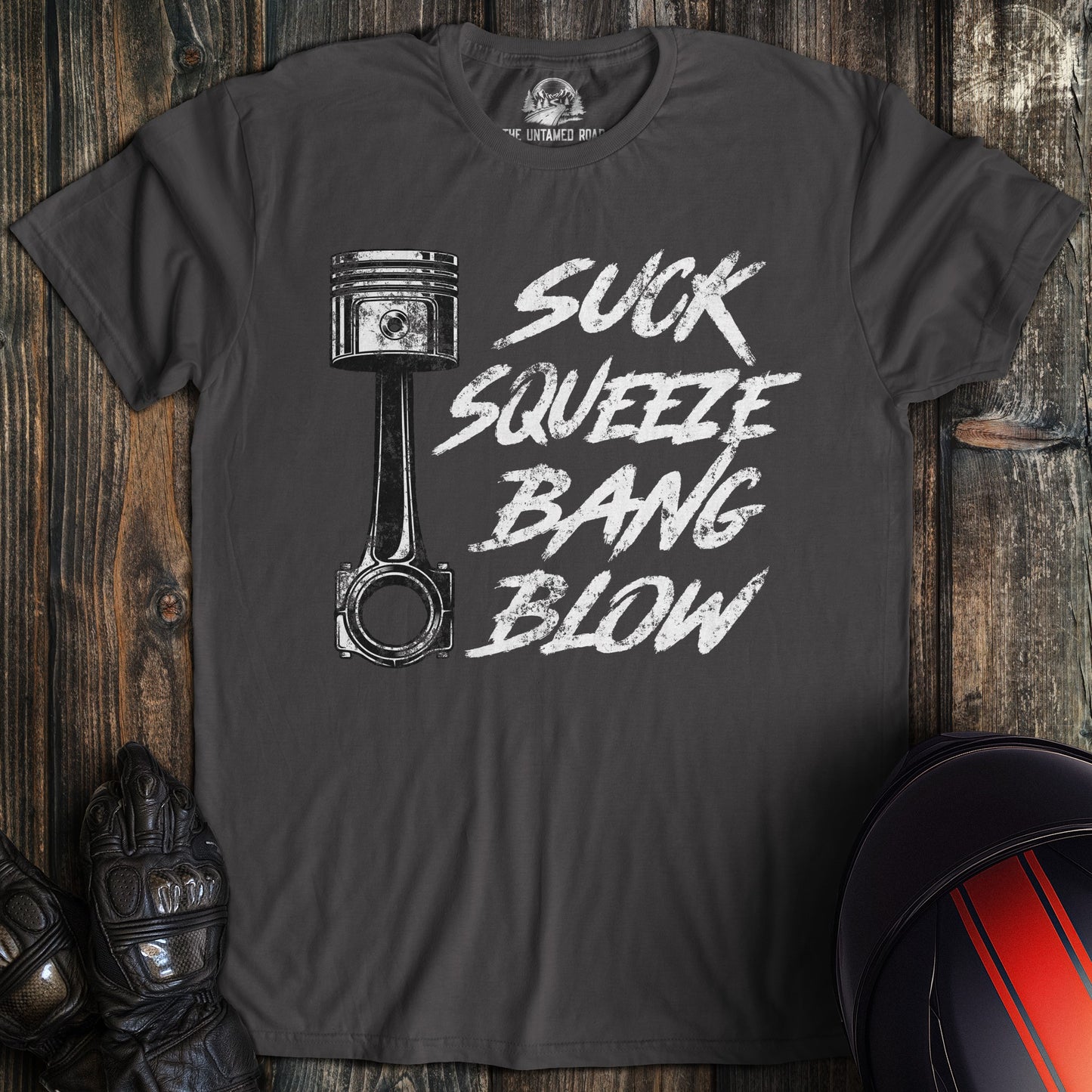A charcoal colored t-shirt with the words "suck squeeze bang blow" printed on the front.