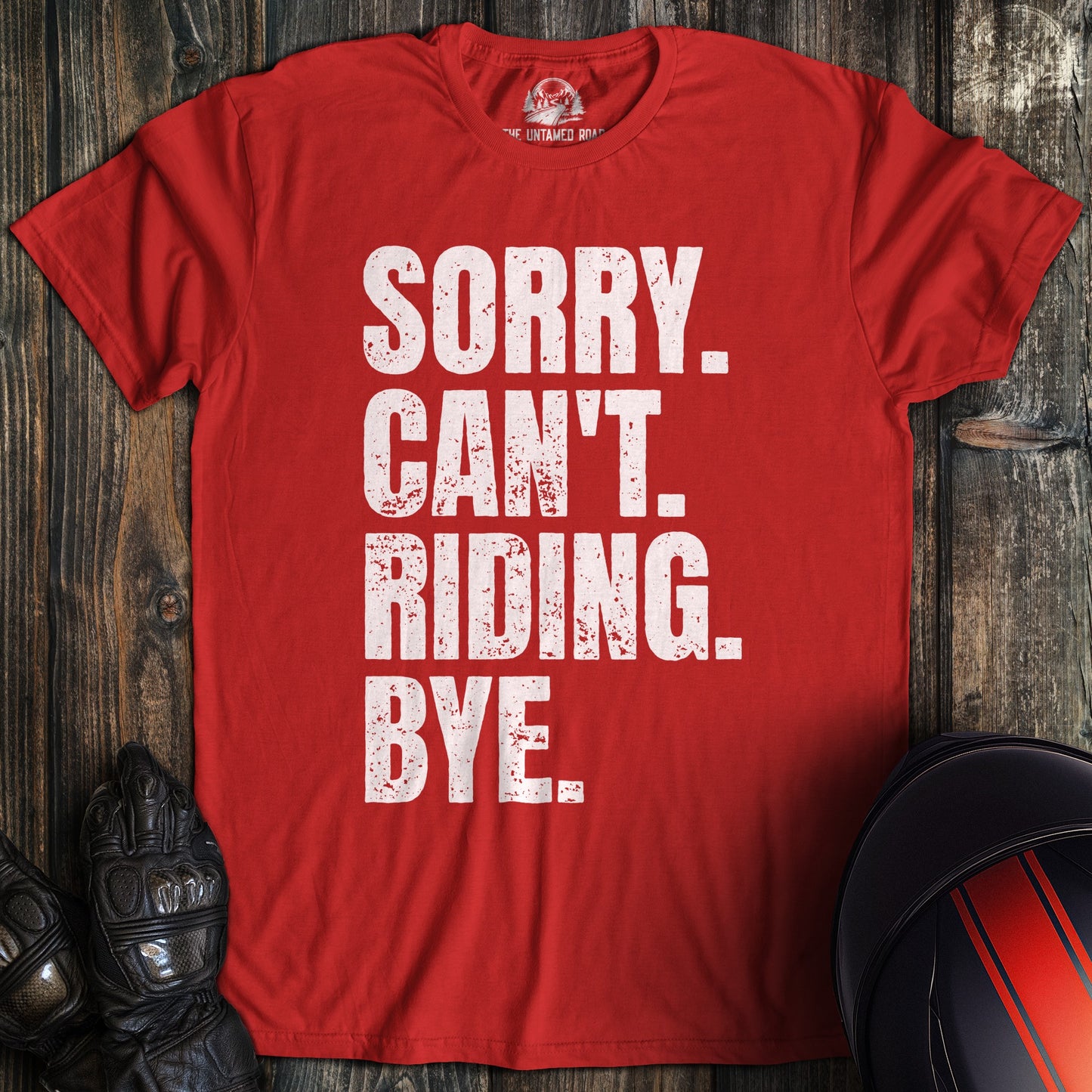 A red t-shirt with white distressed text that reads, SORRY. CAN'T. RIDING. BYE.