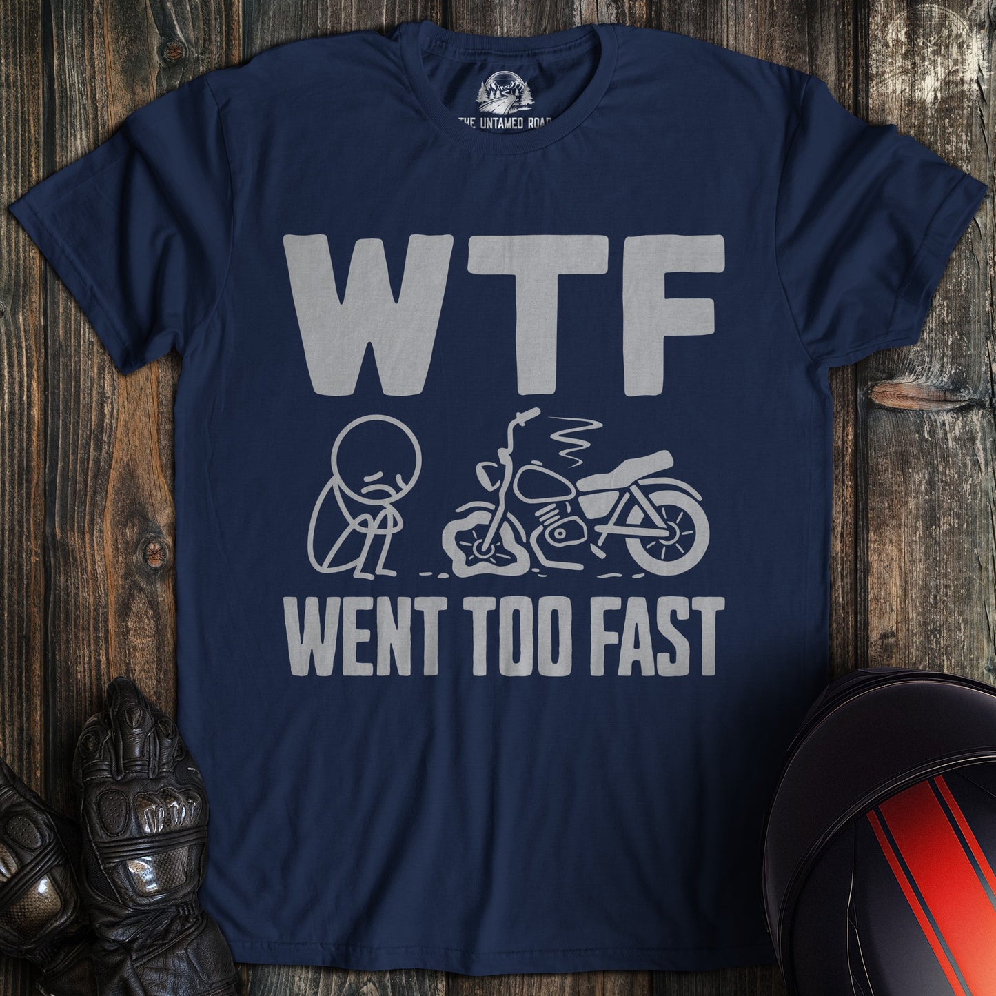 A navy blue t-shirt featuring a funny graphic of a sad stick figure next to a crashed motorcycle and the text WTF.