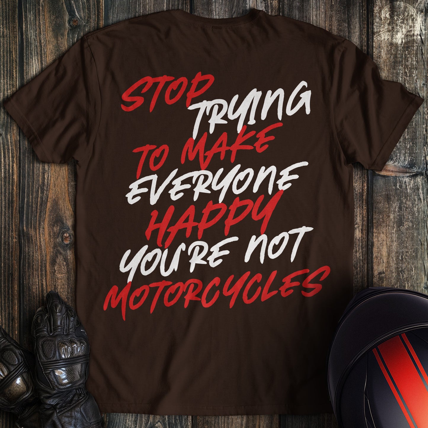 A dark brown t-shirt with red and white text that reads, Stop Trying To Make Everyone Happy You're Not Motorcycles.
