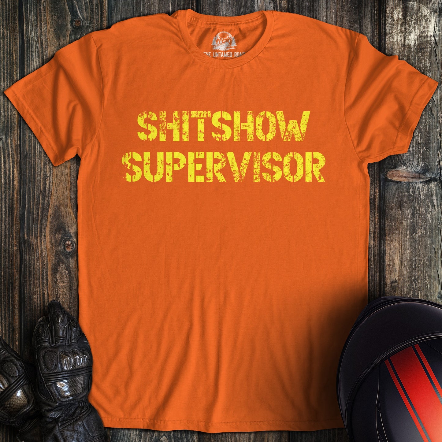 A orange colored t-shirt with the words "shitshow supervisor" printed on the front.
