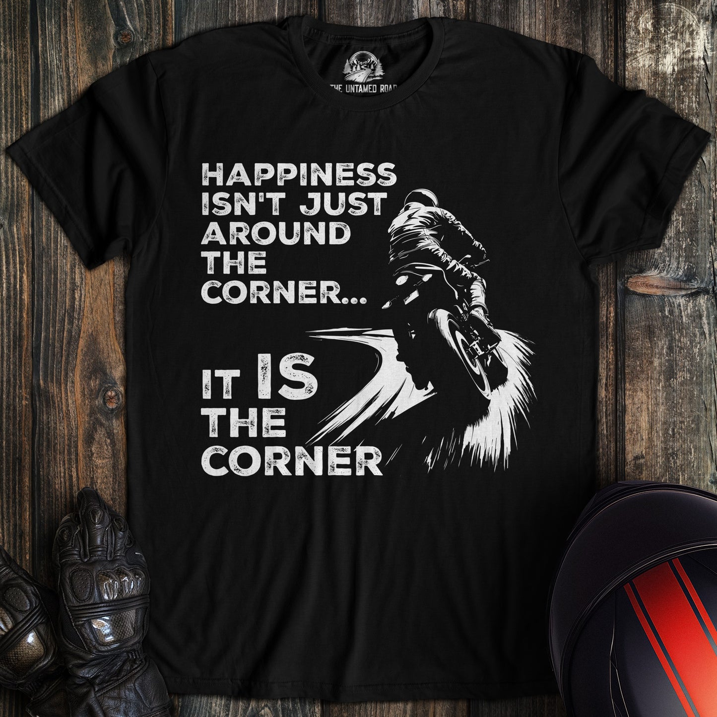 A black colored t-shirt with the words "happiness is the corner" printed on the front.