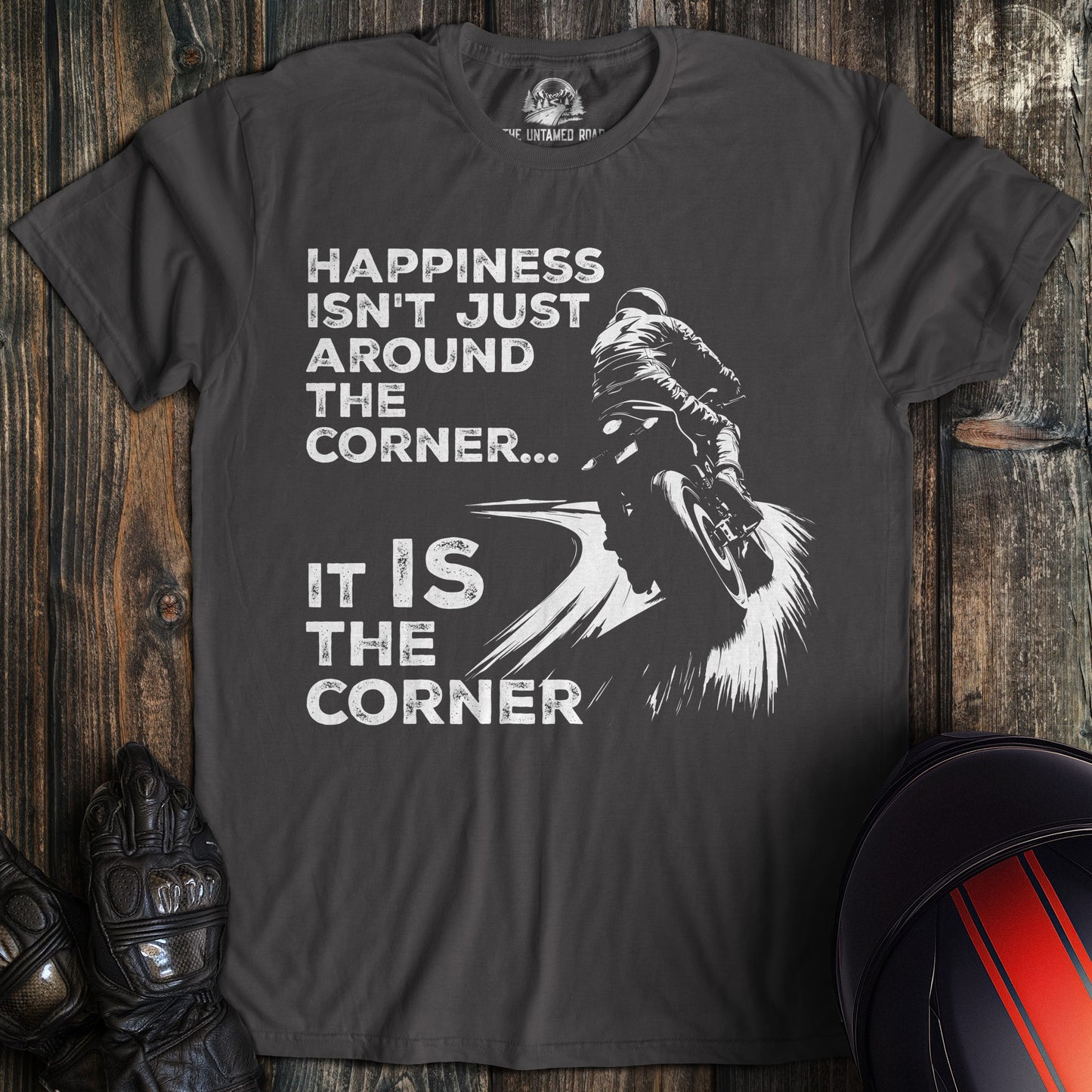 A charcoal colored t-shirt with the words "happiness is the corner" printed on the front.