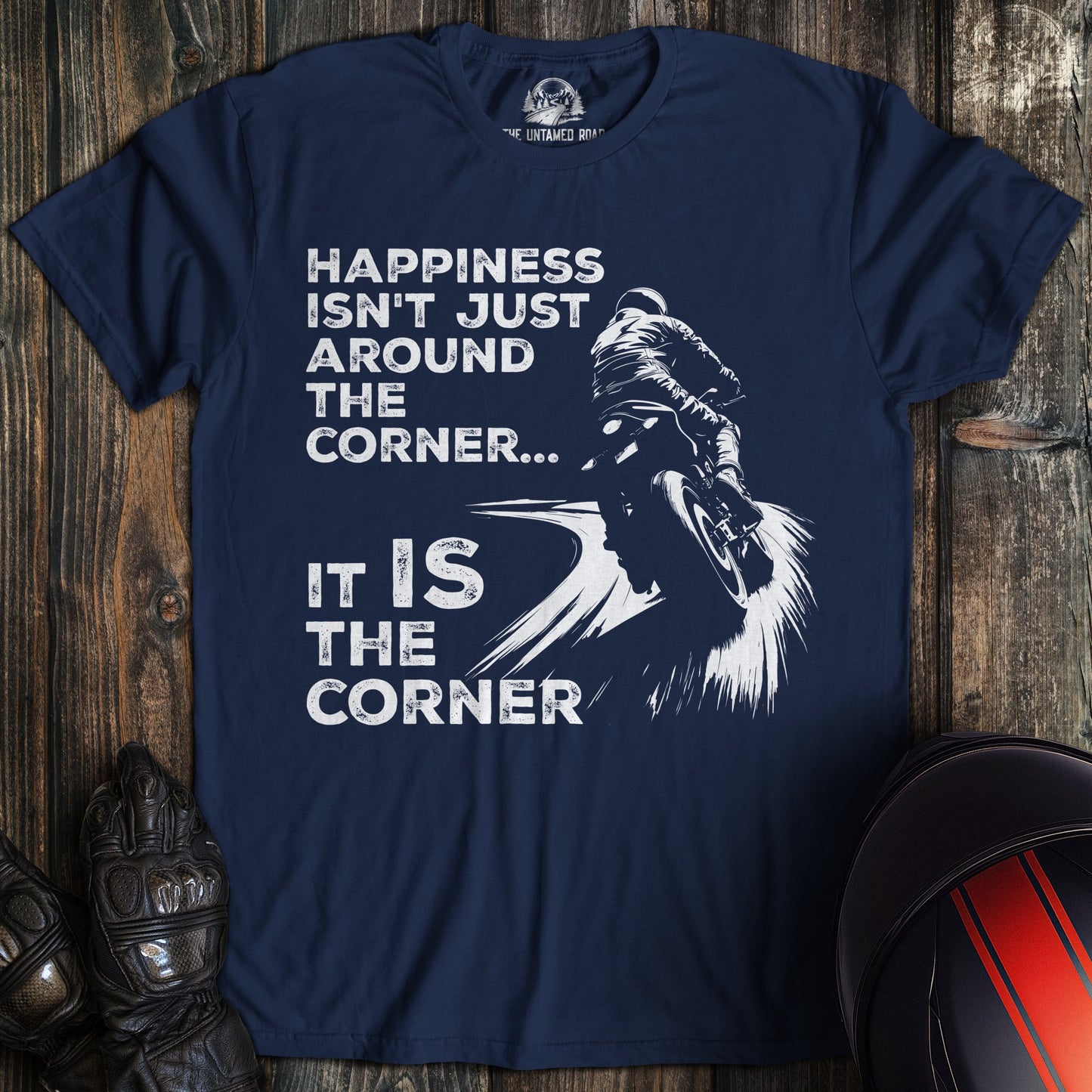 A navy colored t-shirt with the words "happiness is the corner" printed on the front.