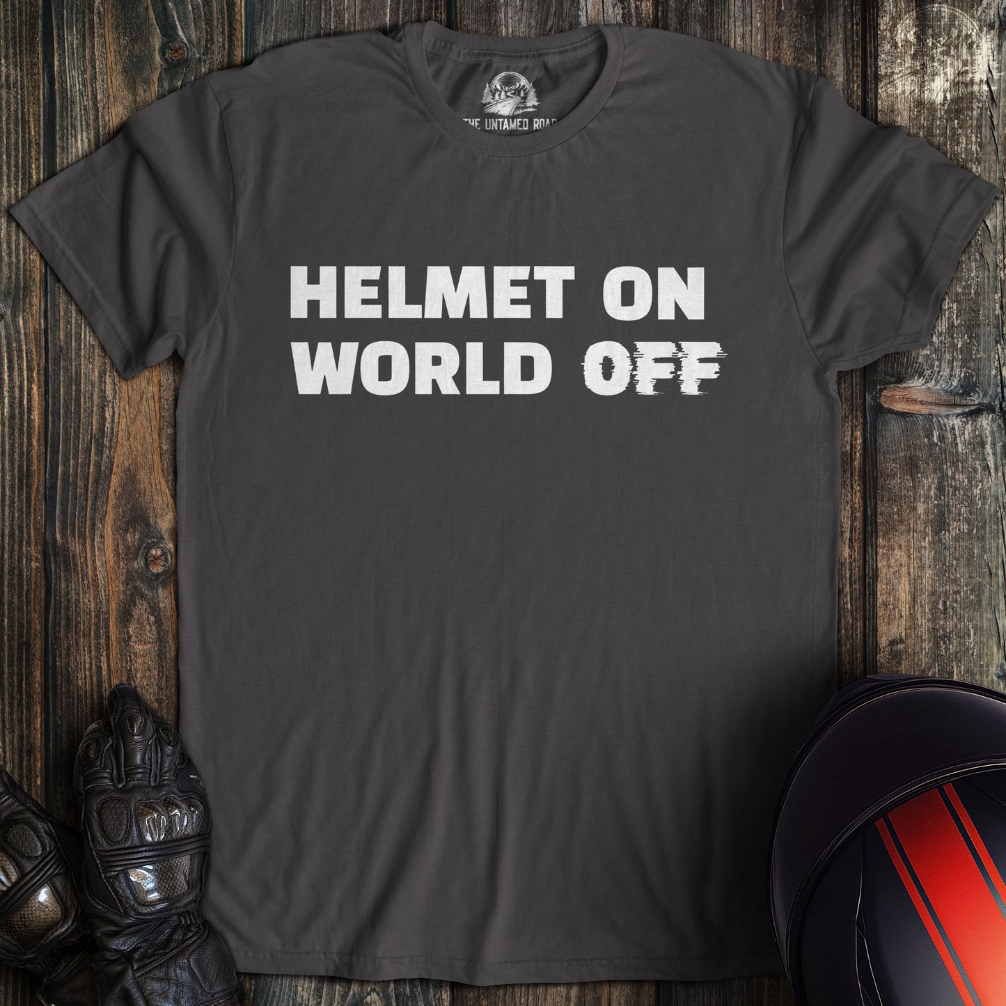 A charcoal colored t-shirt with the words "helmet on world off" printed on the front.
