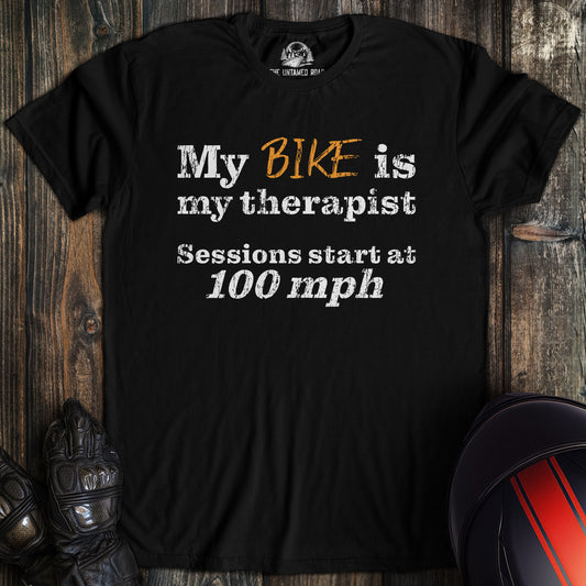 A black colored t-shirt with the words "bike is therapist" printed on the front.
