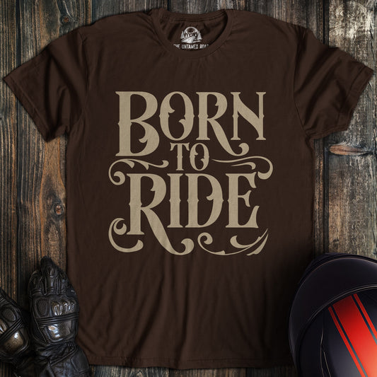 A dark chocolate colored t-shirt with the words "born to ride gothic" printed on the front.