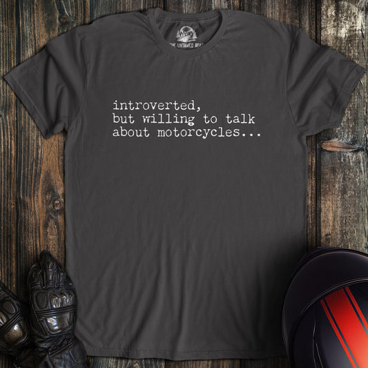 A charcoal colored t-shirt with the words "introverted but willing to talk" printed on the front.