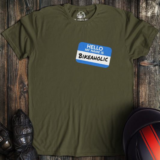 A military green colored t-shirt with the words "bikeaholic nametag" printed on the front.