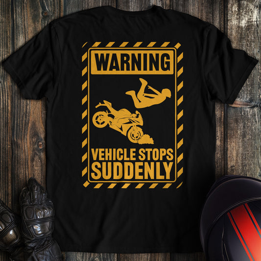A black colored t-shirt with the words "warning vehicle stops suddenly" printed on the back.